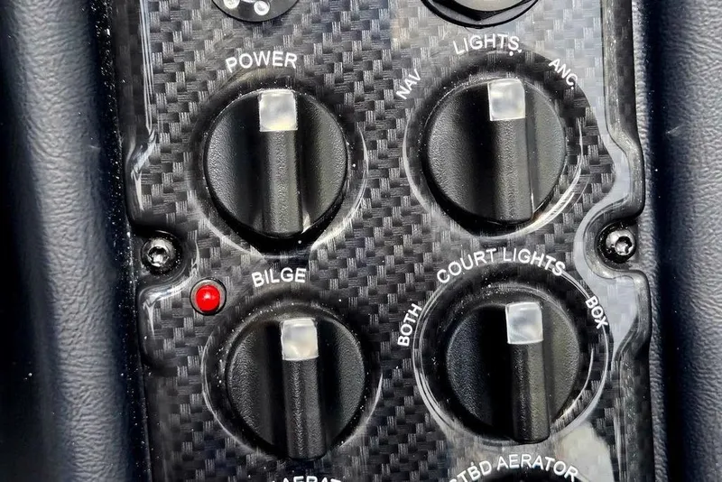 Slide: The Image of Close-up of 2027 Phoenix 721 ZXL boat control panel with switches and red indicator light. - 52
