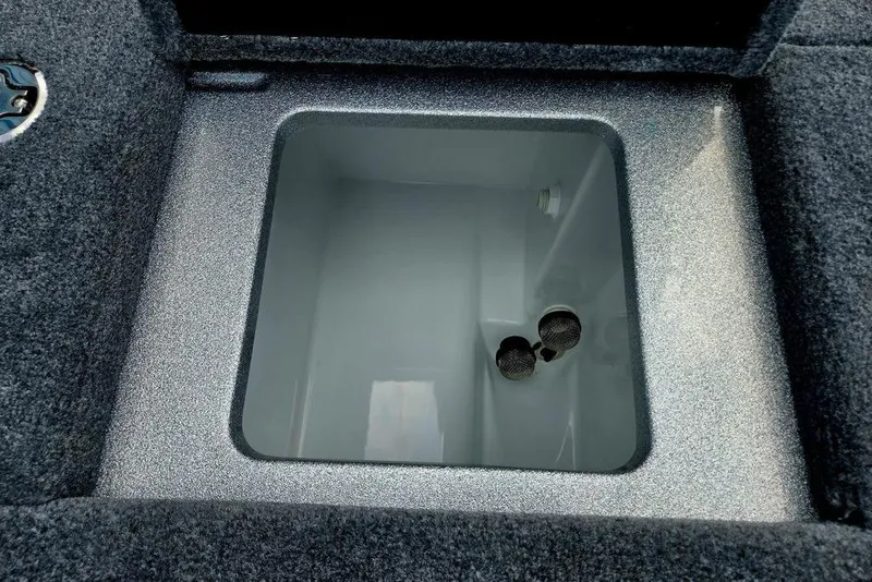 Slide: The Image of Open storage compartment in 2027 Phoenix 721 ZXL boat, featuring carpeted edges and drainage holes. - 57