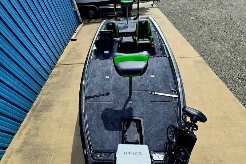 Slide: The Image of 2027 Phoenix 721 ZXL bass boat with green seats and Garmin equipment, parked on concrete. - 67