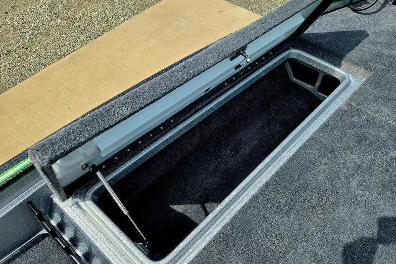 Slide: The Image of Open storage compartment in 2027 Phoenix 721 ZXL boat, featuring carpeted interior and hydraulic lift. - 26