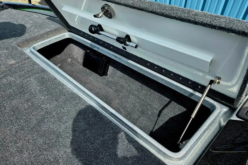 Slide: The Image of Open storage compartment in 2027 Phoenix 721 ZXL boat, featuring carpeted interior and hydraulic lift. - 27