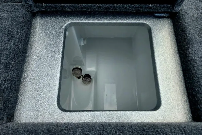 Slide: The Image of 2027 Phoenix 721 ZXL boat storage compartment with gray interior and drainage holes. - 56