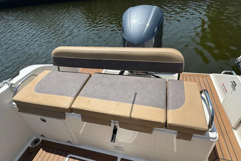 Slide: The Image of 2014 Century 2301 Center Console boat with cushioned seating and outboard motor on water. - 6