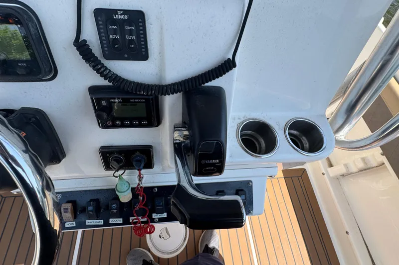 Slide: The Image of Control panel of a 2014 Century 2301 Center Console boat with steering and cup holders. - 15