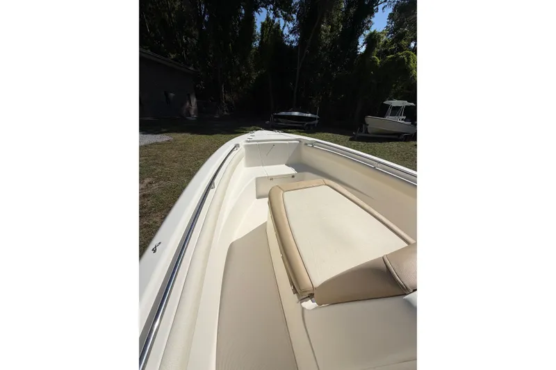Slide: The Image of 2012 Scout 210 XSF boat interior with beige seating, parked outdoors. - 10