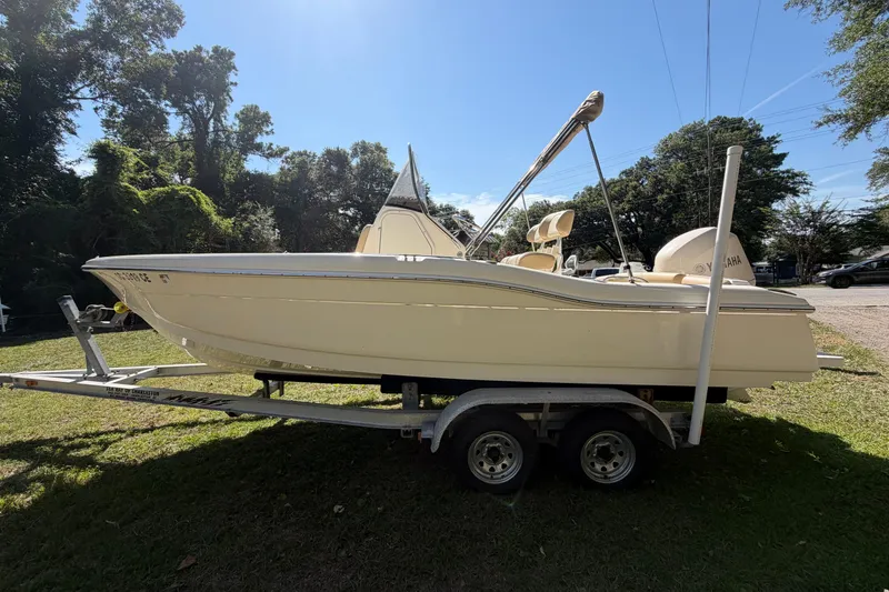 Slide: The Image of 2012 Scout 210 XSF boat on trailer, parked on grass, sunny day. - 5