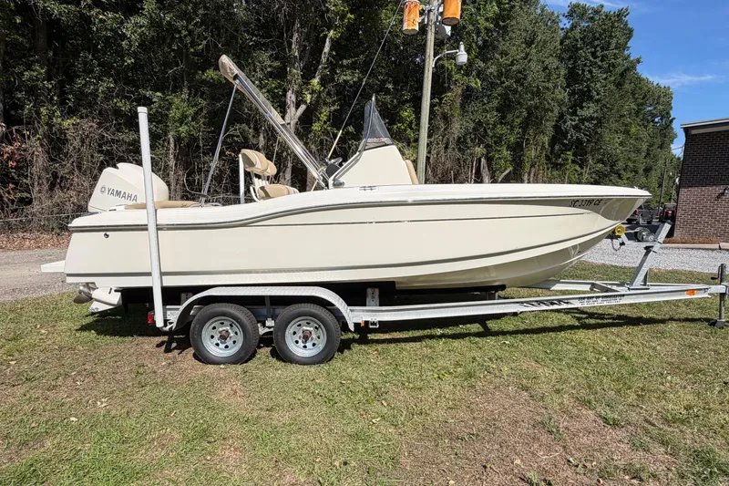 The Image of 2012 Scout 210 XSF boat on trailer with Yamaha engine, parked on grass. - 4
