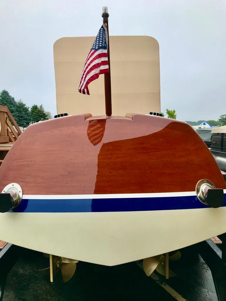Slide: The Image of Custom 2020 Windlea Runabout boat with American flag, polished wood finish, and blue stripe. - 26