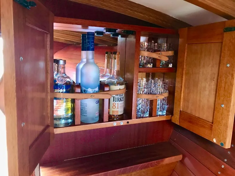 Slide: The Image of Wooden cabinet with liquor bottles and glasses in a 2020 Custom Windlea Runabout. - 11