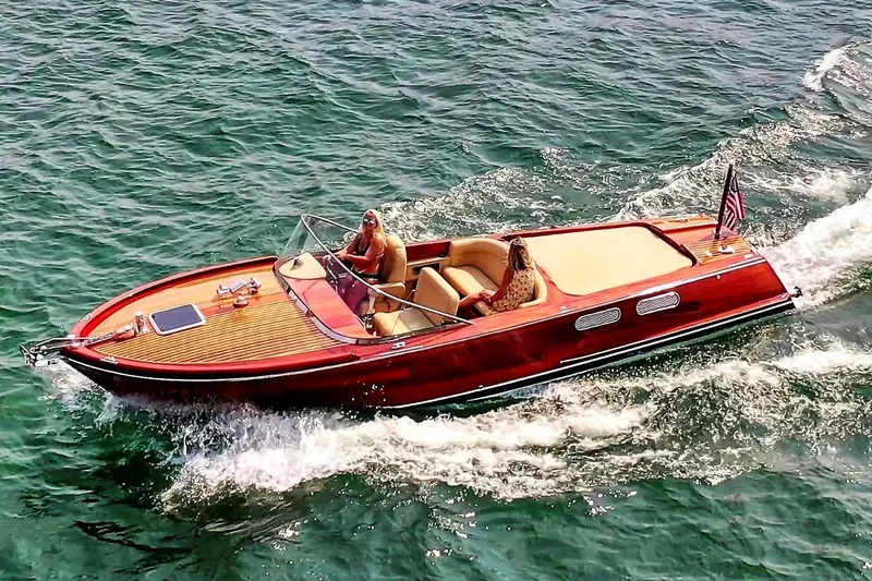 Slide: The Image of Custom Windlea 28 Runabout 2020 cruising on open water, showcasing elegant wooden design. - 2