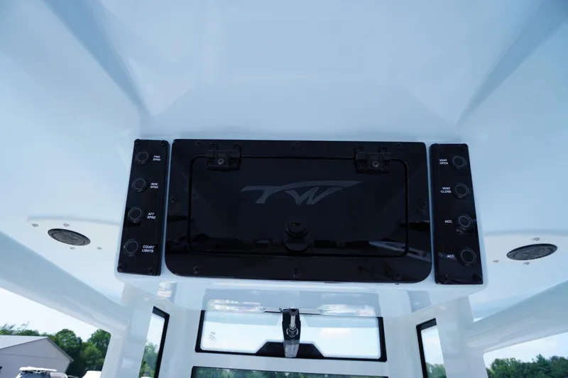Slide: The Image of Control panel of 2026 Tidewater 232 CC Adventure boat, featuring various switches and a central display. - 46