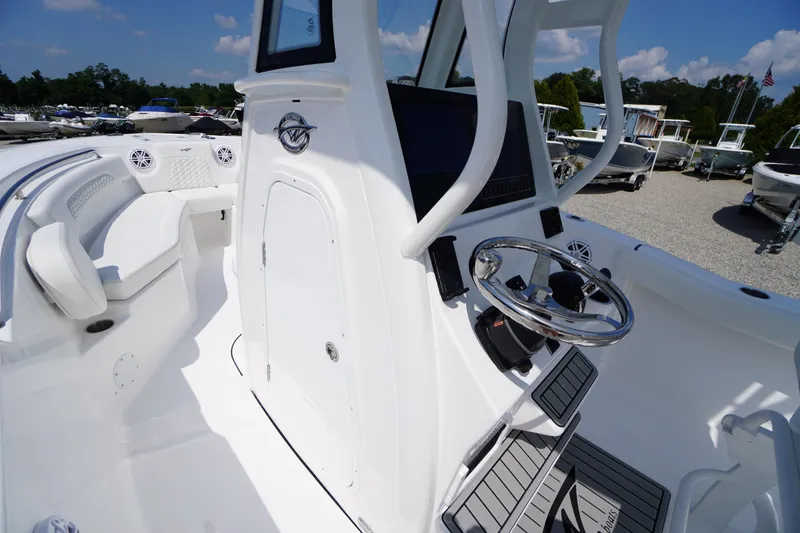 Slide: The Image of 2026 Tidewater 232 CC Adventure boat interior with steering wheel and seating area. - 27