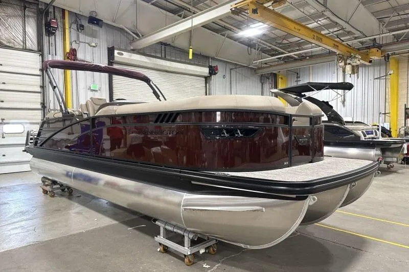 The Image of 2026 Bennington 24 LXS Quadbench pontoon boat in a warehouse setting. - 0