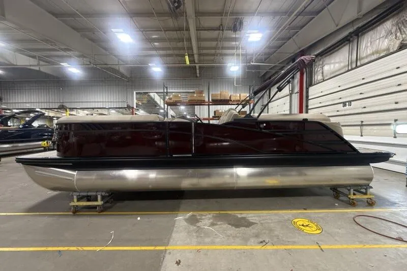 Slide: The Image of 2026 Bennington 24 LXS Quadbench pontoon boat in a spacious indoor facility. - 13