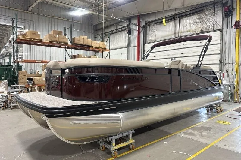 Slide: The Image of 2026 Bennington 24 LXS Quadbench pontoon boat in a warehouse setting. - 2