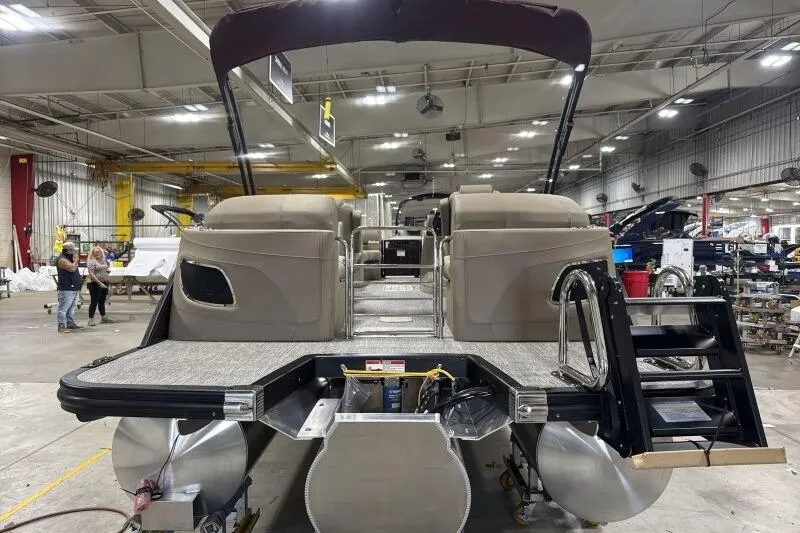Slide: The Image of 2026 Bennington 24 LXS Quadbench pontoon boat in a spacious indoor facility. - 15