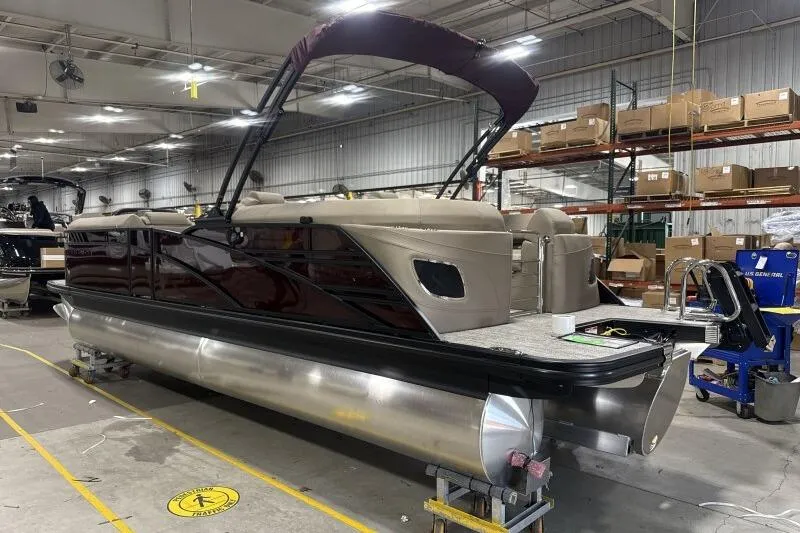 Slide: The Image of 2026 Bennington 24 LXS Quadbench pontoon boat in a warehouse setting. - 14