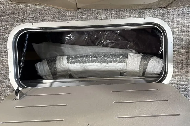 Slide: The Image of Storage compartment of 2026 Bennington 24 LXS Quadbench, showcasing interior space and materials. - 5