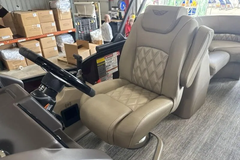 Slide: The Image of 2026 Bennington 24 LXS Quadbench boat interior with luxurious captain's chair and steering wheel. - 10