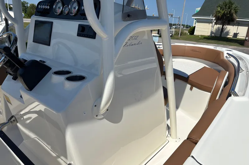 Slide: The Image of 2027 Pioneer 202 Islander boat interior with steering console and cushioned seating. - 22