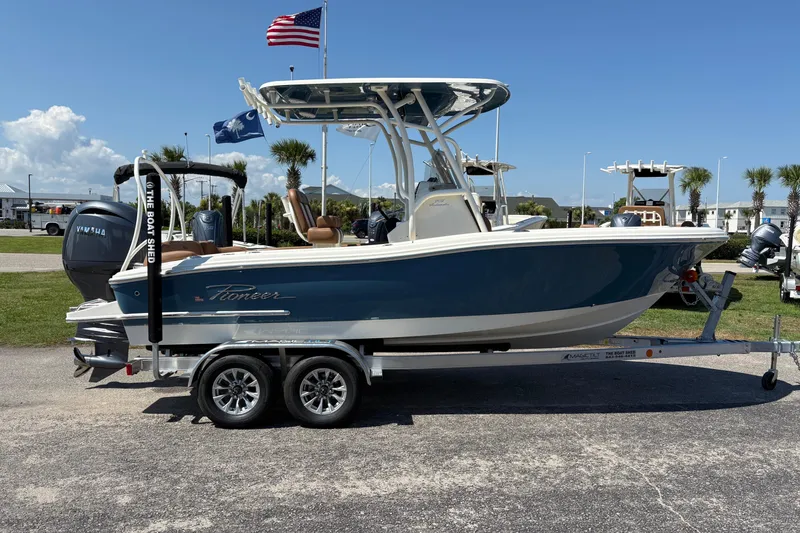 Slide: The Image of 2027 Pioneer 202 Islander boat on trailer, parked outdoors under clear sky. - 4
