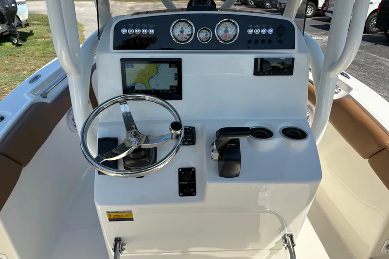 Slide: The Image of 2027 Pioneer 202 Islander boat dashboard with steering wheel, gauges, and navigation display. - 18