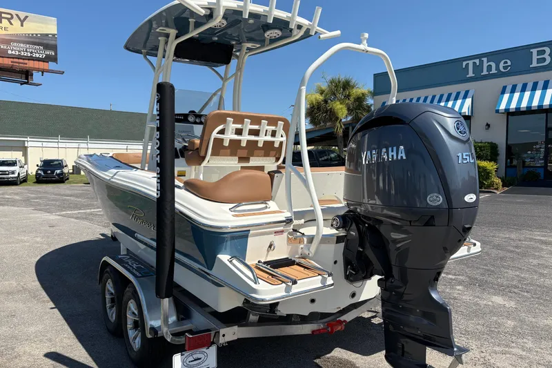 Slide: The Image of 2027 Pioneer 202 Islander boat with Yamaha 150 engine, parked outdoors on a trailer. - 2