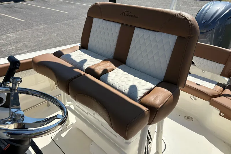 Slide: The Image of 2027 Pioneer 202 Islander boat interior with brown and white cushioned seating. - 13