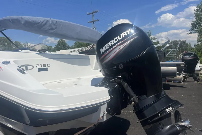 Slide: The Image of 2017 Tahoe 2150 boat with Mercury FourStroke engine, parked outdoors under a clear blue sky. - 15
