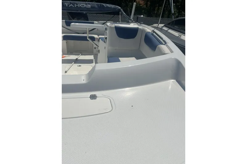 Slide: The Image of 2017 Tahoe 2150 boat interior with white and blue seating, spacious deck. - 13