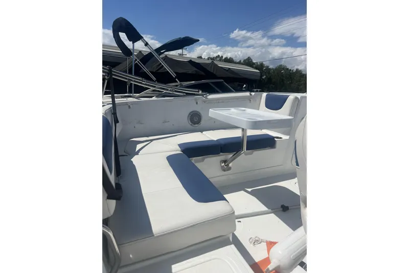 Slide: The Image of 2017 Tahoe 2150 boat interior with white seating and a small table. - 11