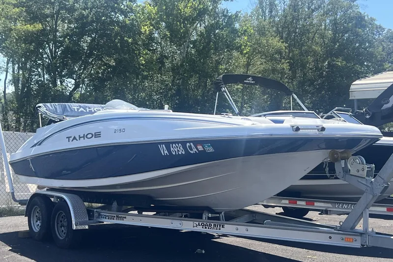 The Image of 2017 Tahoe 2150 boat on trailer, parked outdoors with trees in background. - 0