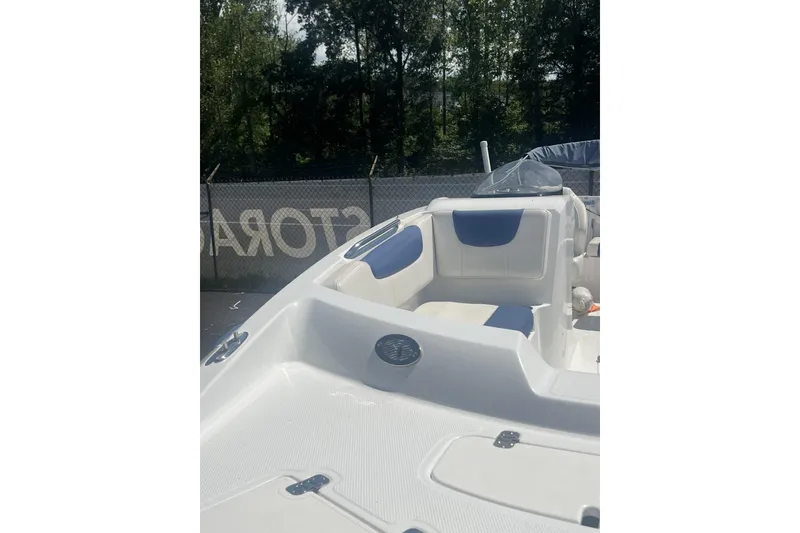 Slide: The Image of 2017 Tahoe 2150 boat interior with white and blue seating, parked outdoors. - 5
