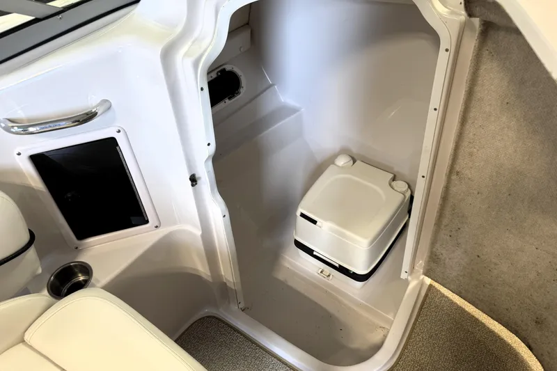 Slide: The Image of 2008 Four Winns H240 boat interior with compact portable toilet and storage compartment. - 31