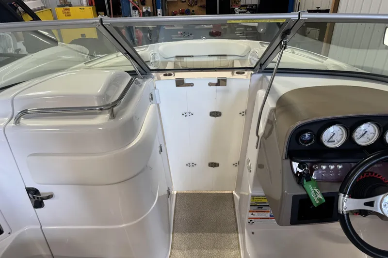 Slide: The Image of Interior view of a 2008 Four Winns H240 boat cockpit with steering wheel and gauges. - 33