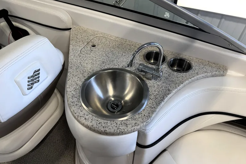 Slide: The Image of 2008 Four Winns H240 boat interior with sink and cup holders. - 18