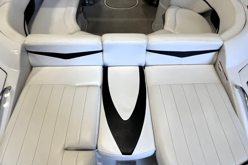 Slide: The Image of 2008 Four Winns H240 boat interior with white cushioned seating and black accents. - 24