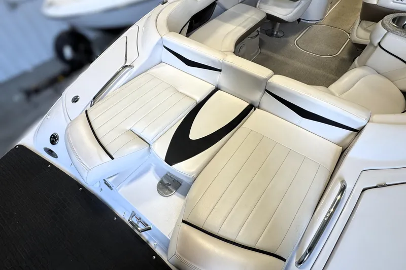 Slide: The Image of Interior seating of a 2008 Four Winns H240 boat, featuring white and black upholstery. - 23