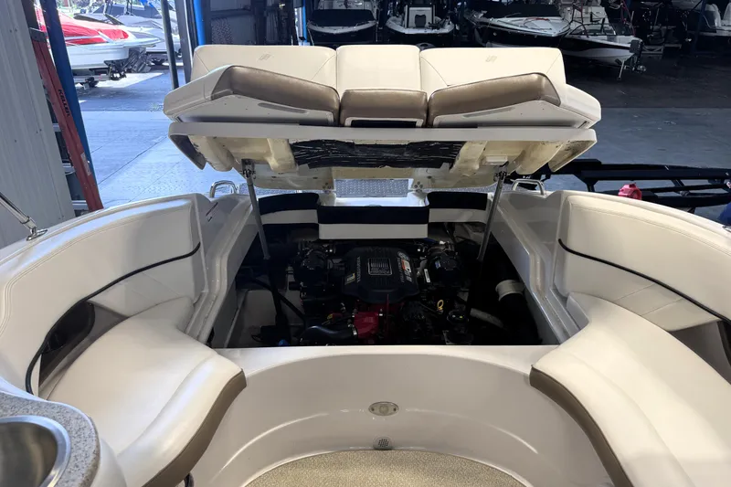 Slide: The Image of 2008 Four Winns H240 boat interior with open engine compartment in a showroom. - 14