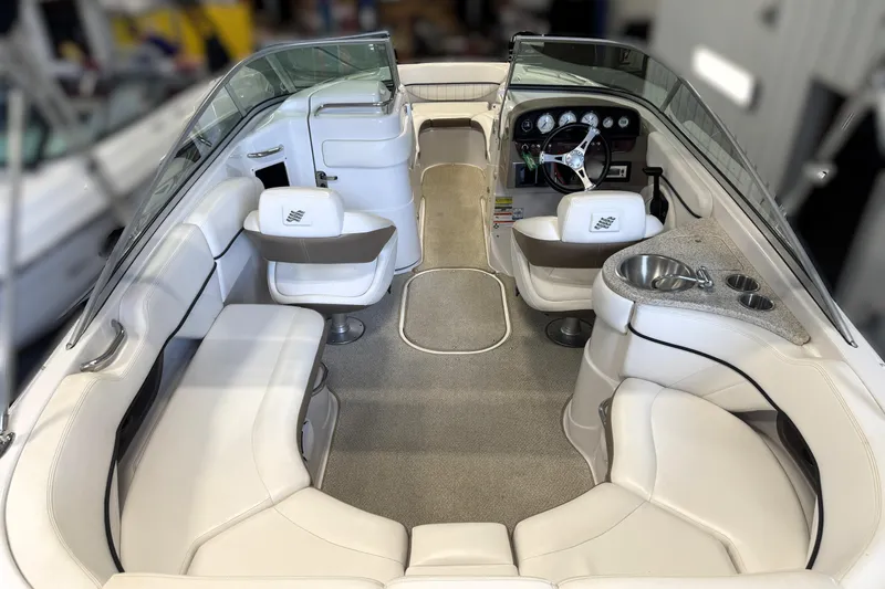 Slide: The Image of 2008 Four Winns H240 boat interior with white seating and steering console. - 27