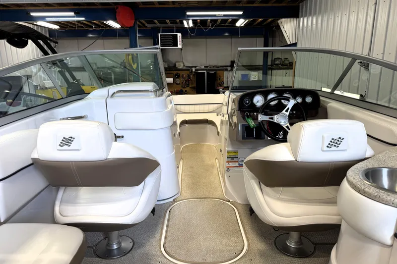 Slide: The Image of Interior of a 2008 Four Winns H240 boat with white seating and steering console. - 28