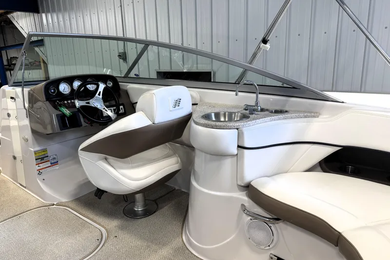 Slide: The Image of 2008 Four Winns H240 boat interior with steering wheel, seating, and sink. - 12