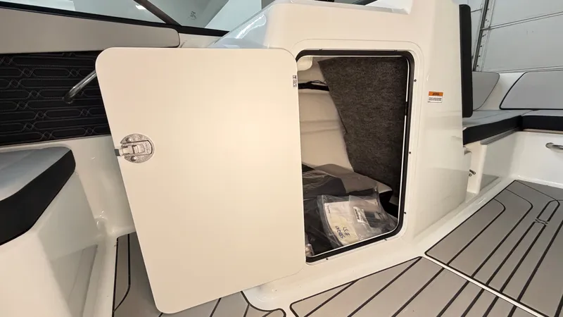 Slide: The Image of The 2026 Sea Ray SPX 210 features an open storage compartment with gray carpeting. - 45
