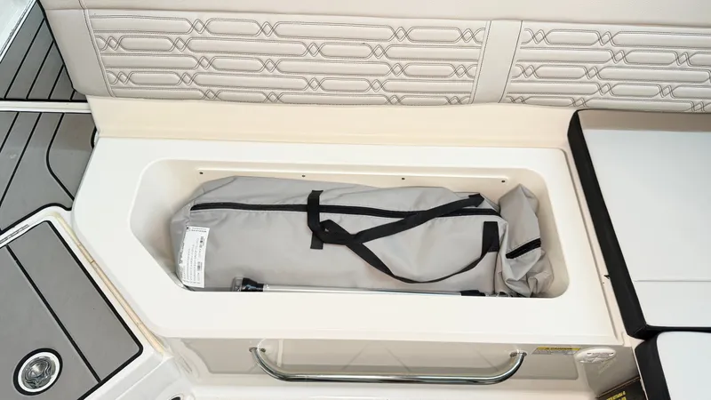 Slide: The Image of A storage compartment on a Sea Ray SPX 210 boat with a gray bag inside. - 18