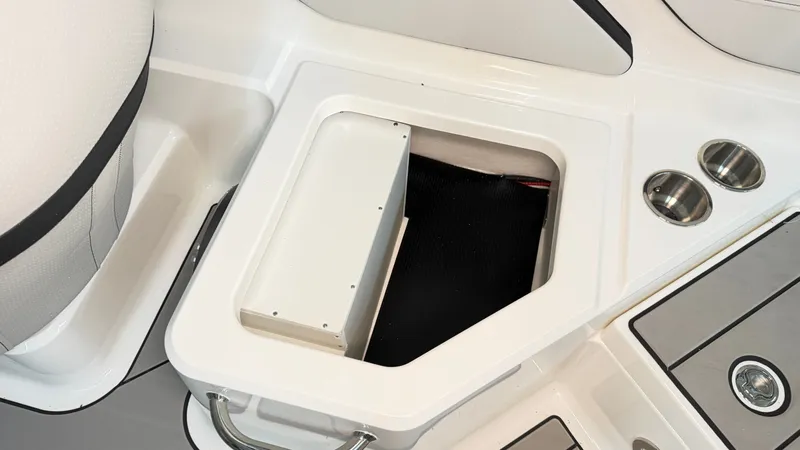 Slide: The Image of An open storage compartment on a Sea Ray SPX 210 boat with cup holders beside it. - 28