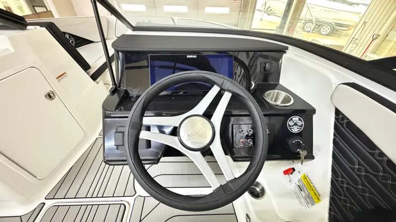 Slide: The Image of The cockpit of the 2026 Sea Ray SPX 210 features a modern steering wheel and a display screen. - 40