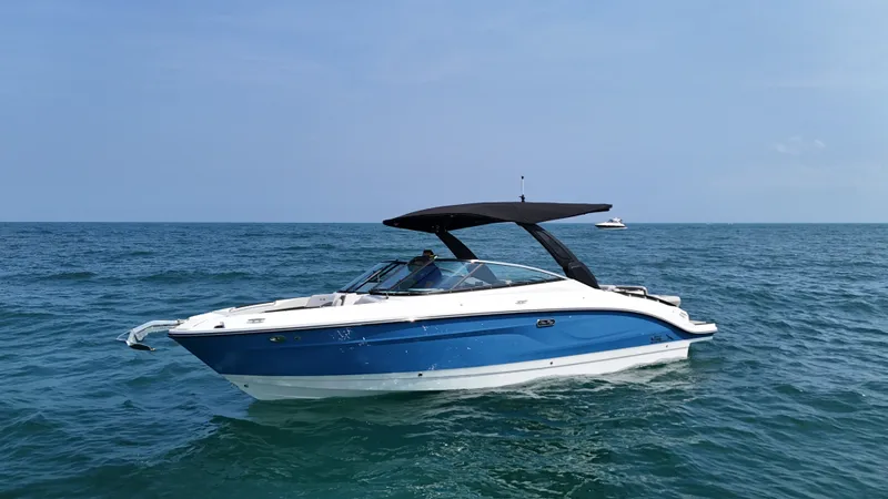 Slide: The Image of A 2027 Sea Ray SLX 280 on calm waters, featuring a blue hull and black sunshade. - 1