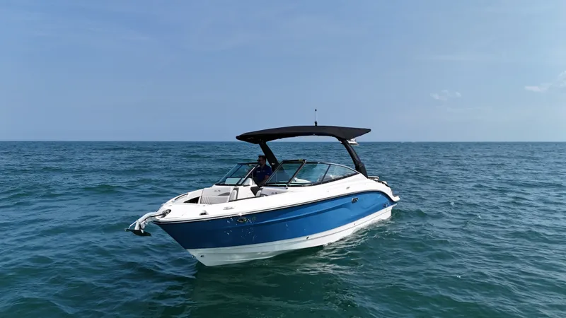Slide: The Image of 2027 Sea Ray SLX 280 on calm sea with blue hull and black canopy. - 2