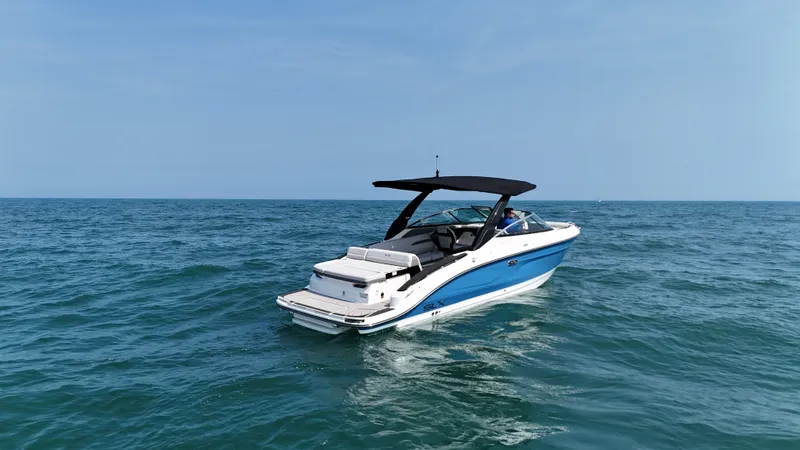 Slide: The Image of A 2027 Sea Ray SLX 280 on open water. It features a blue and white design with a black canopy. - 5