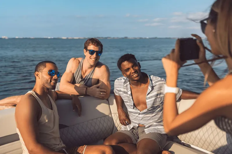 Slide: The Image of Three men pose on a Sea Ray SLX 280 boat while a woman takes a photo. - 34